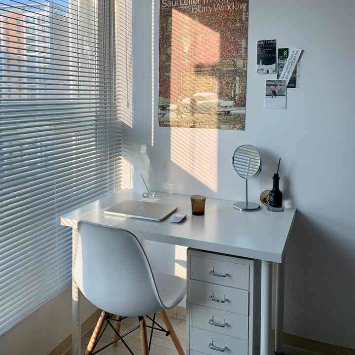 明るいホワイトトーンのホームオフィス、IKEAの引き出しユニットとデスク、アルミブラインドが整然と配置されたミニマルなインテリア