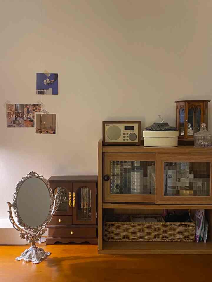 温かみのあるブラウン調のワンルーム寝室、デスク兼用の化粧台と多機能収納キャビネットが配置された居心地の良い空間