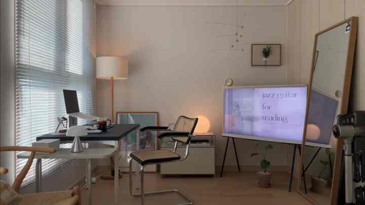 ナチュラルな木目調とホワイトが調和するホームオフィス、黒いデスクとオフィスチェアが配置されたミニマルな作業空間