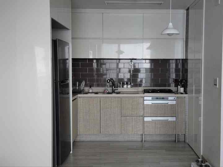 明るいグレーとブラウンのトーンが特徴の、一人暮らし向けのコンパクトなキッチン、モダンで清潔感のある配置