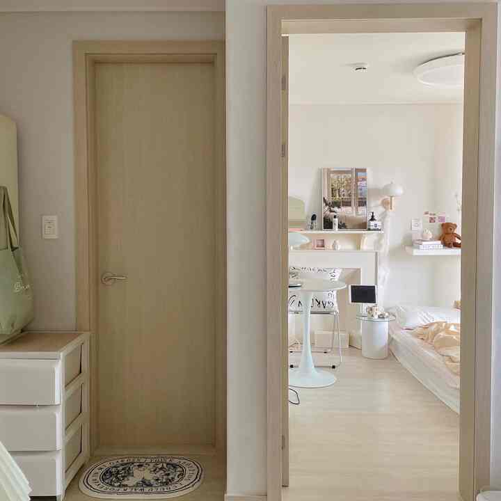 白とナチュラルトーンの寝室、整頓されたドレッサーとマットレスベッドが配置された温かみのある空間