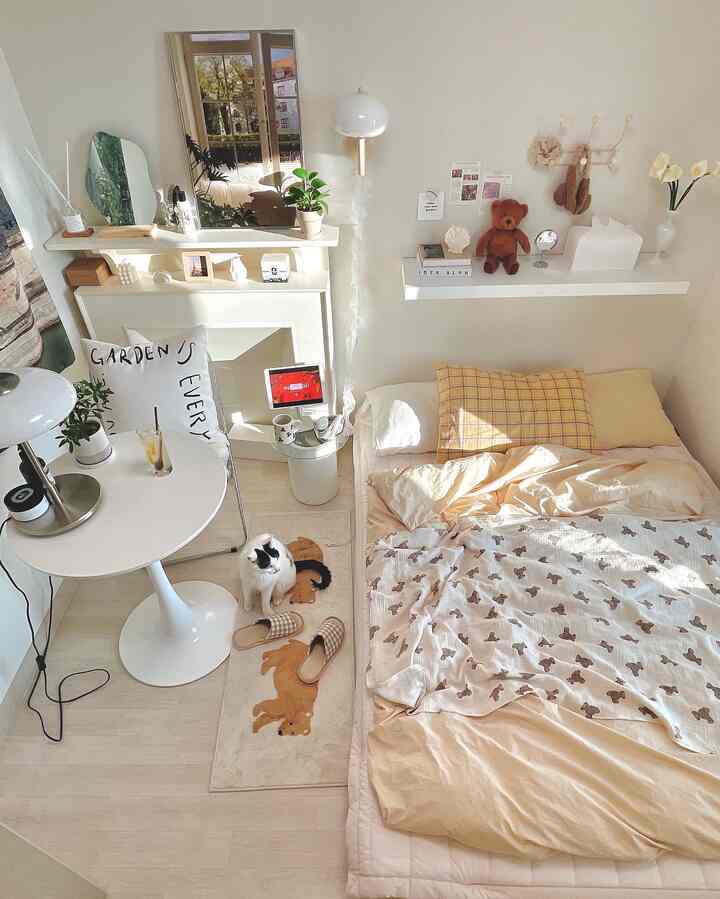 ホワイトとベージュの調和がとれた寝室、猫とかわいらしいオブジェが配置された温かみのあるインテリア