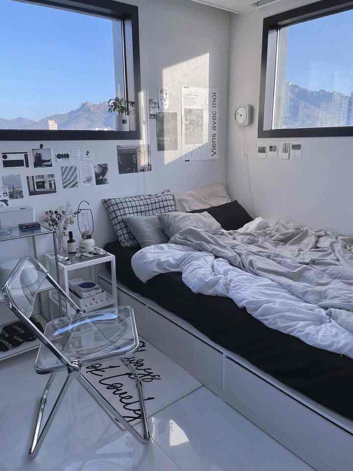 ホワイトとグレーのトーンのコンパクトな寝室、透明なチェアとベッドが配置されたモダンで清潔感のあるインテリア