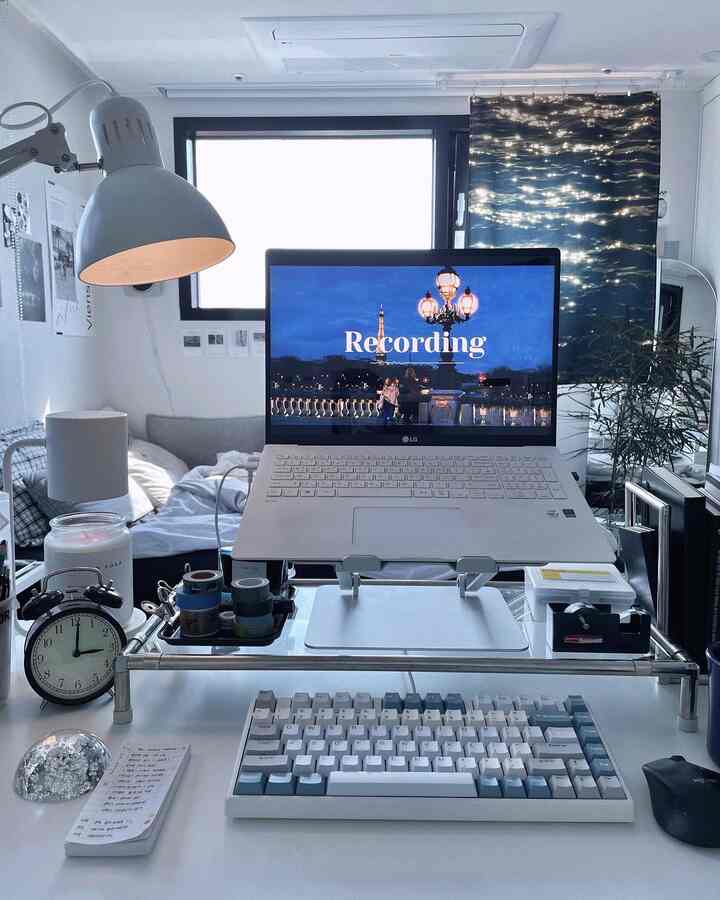 ホワイトとグレーのトーンが映えるホームオフィス空間で、ノートパソコンとデスクが中央に配置された清潔感のある印象的なインテリア