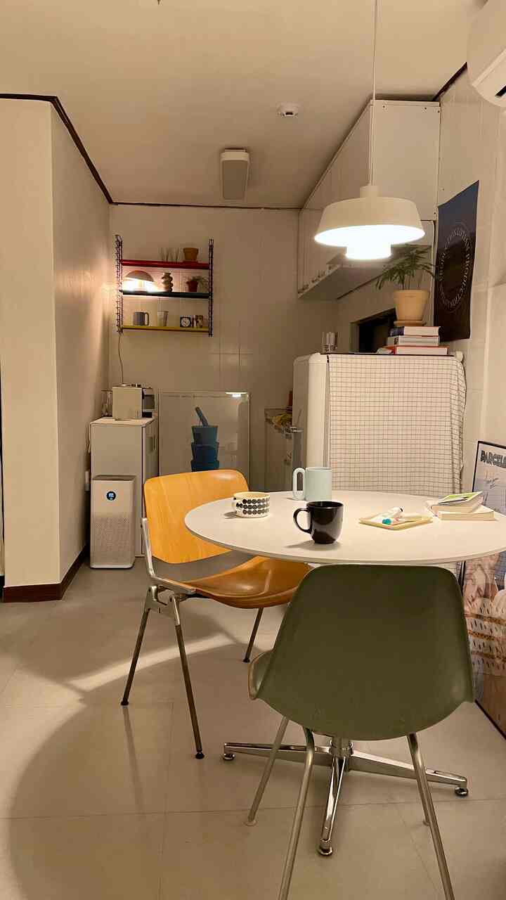 ホワイトとウッドトーンの調和が美しい二人用ダイニング、シンプルモダンな丸テーブルとマグカップが特徴的な空間