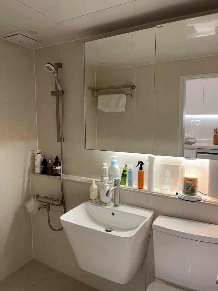 暖かみのあるベージュ調のバスルーム、ニッケル製の水栓とタオル掛けが配置された清潔感のあるインテリア