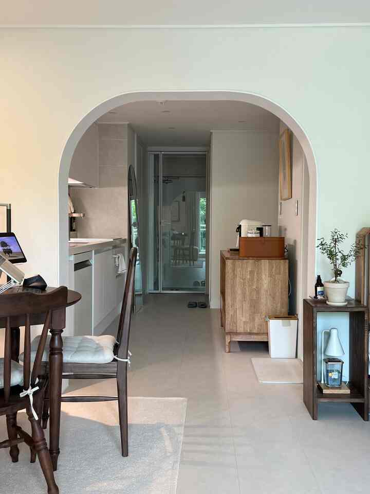 ホワイトと木目調が調和したキッチンとダイニング、スリムな棚が置かれた落ち着いた雰囲気の空間