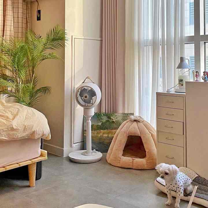 ベージュとグレーの色調のリビング、犬用のペットハウスとチェストが配置された落ち着いた自然な雰囲気のインテリア