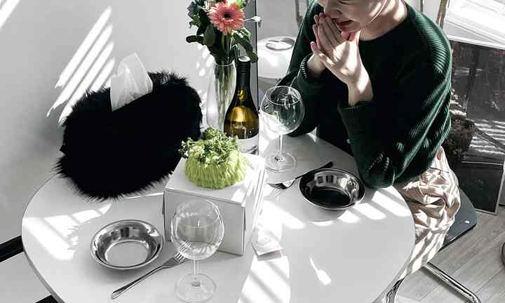 白い丸いテーブルと黒い毛のペット犬がいるモダンなダイニングスペース