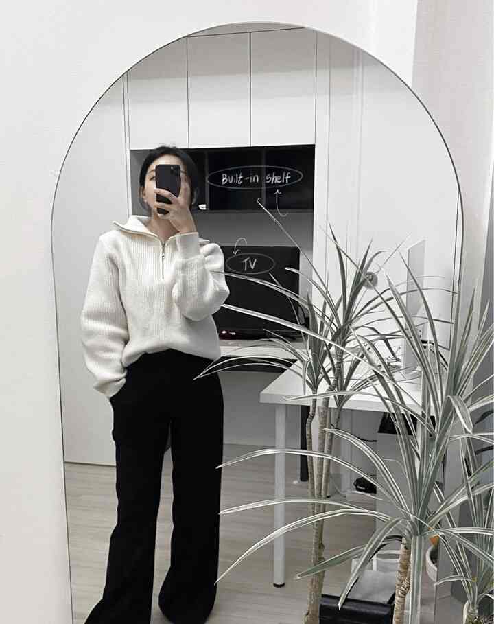 白と黒のトーンのホームオフィス空間、デスクとビルトイン棚、テレビが配置されたシンプルでモダンな作業スペース