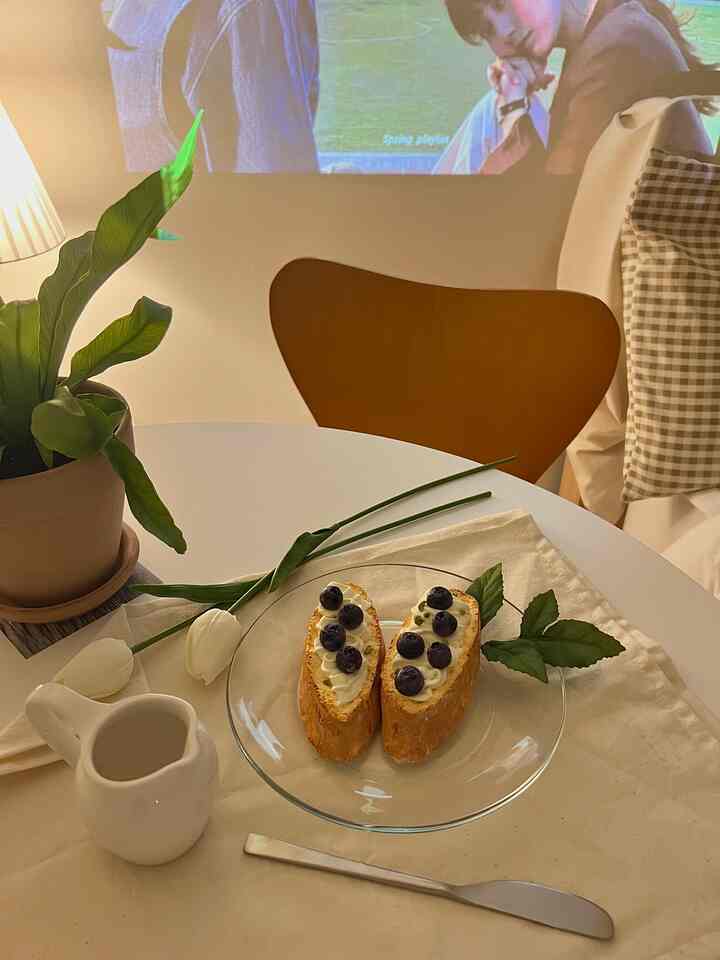 柔らかなホワイトと木目調が調和した丸テーブルと木製椅子が配置されたナチュラルな雰囲気のおうちカフェ風インテリア