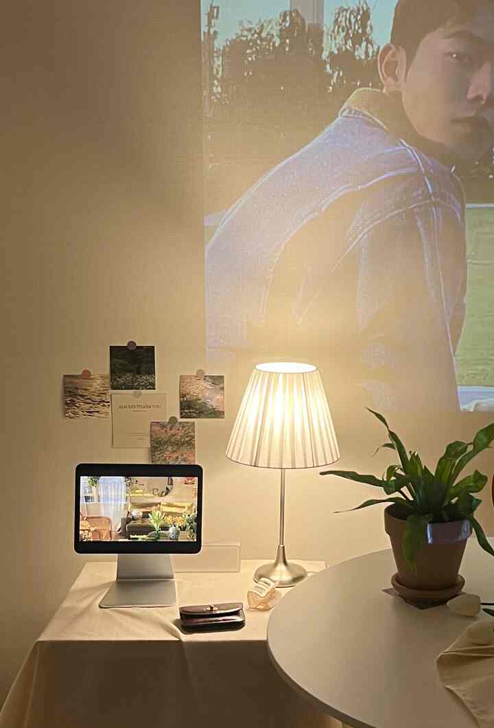 ナチュラルベージュ色調のホームオフィス、ダイニングテーブルとテーブルランプ、植物が配置された温かみのある雰囲気のインテリア