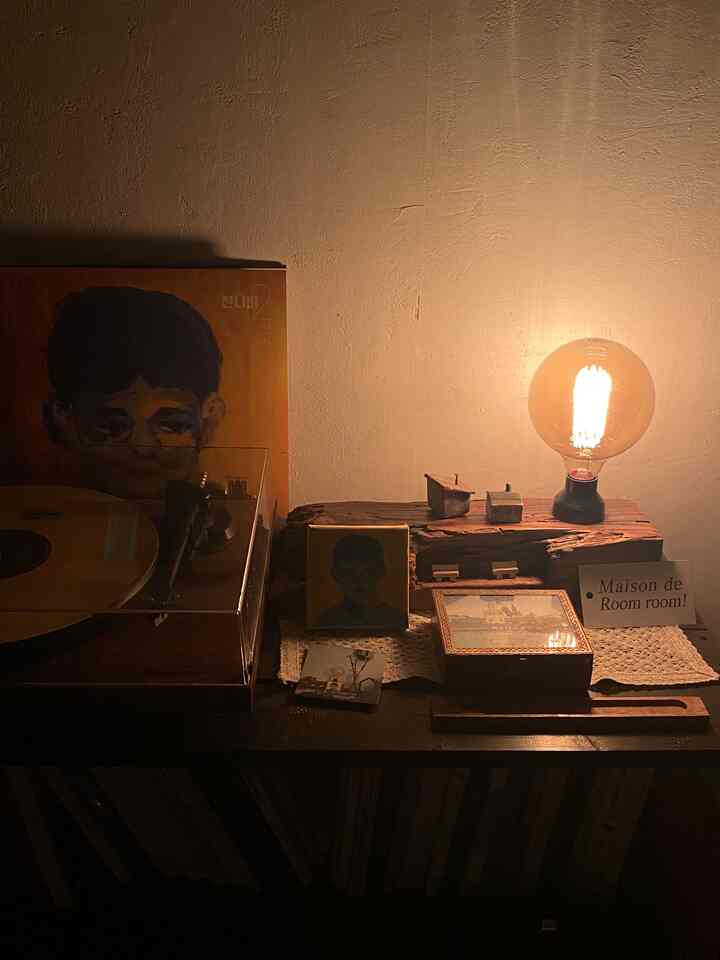 暖かいブラウン調のヴィンテージターンテーブルと装飾が置かれた小さな照明空間