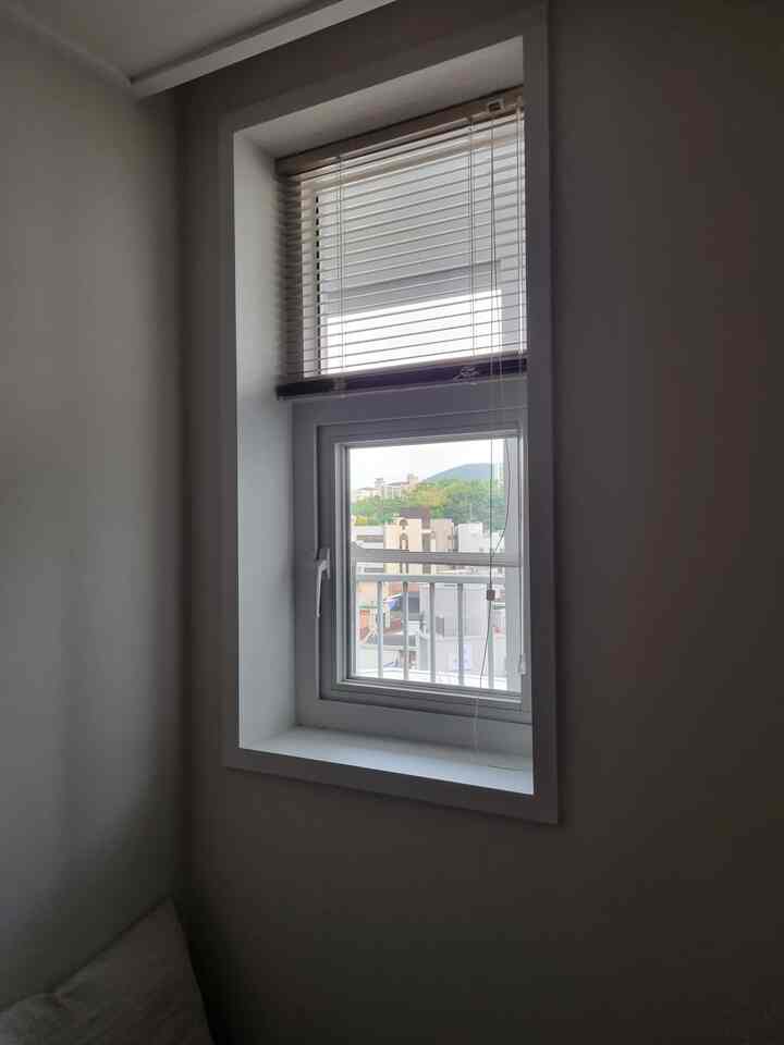 ホワイトトーンの小さな換気窓、アルミニウムブラインドが設置された寝室の一角の空間