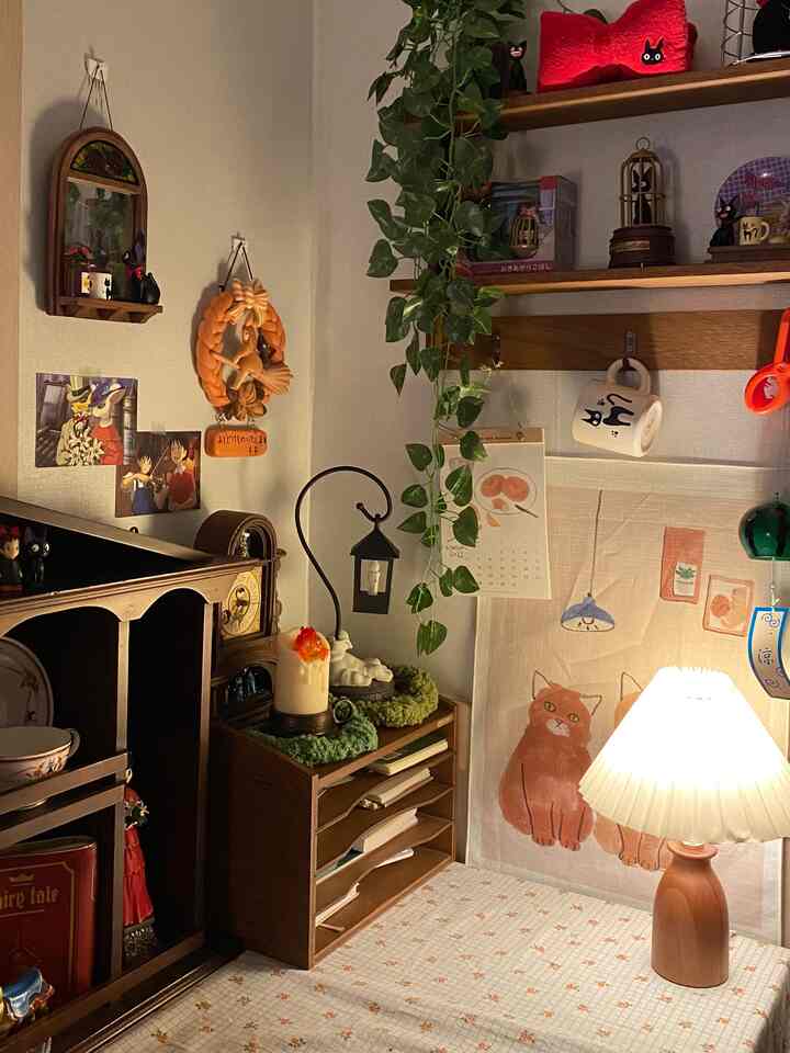 温かみのある木目調とキャンドル、植物、壁棚、小さな可愛らしいオブジェが配置された雰囲気のある空間