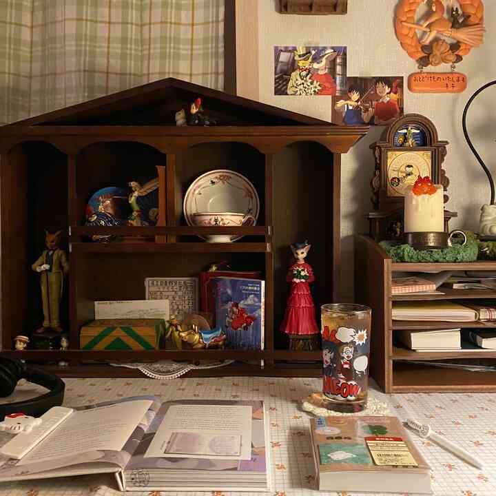 ブラウンの木目調家具と整理棚が配置されたシンプルな書斎、書籍や文具が並びかわいらしい雰囲気のインテリア