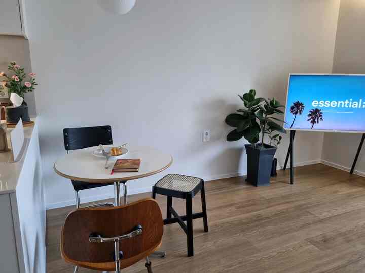 ナチュラルな色調のリビング、丸テーブルと異なる椅子が配され、落ち着いたシンプルな雰囲気のインテリア