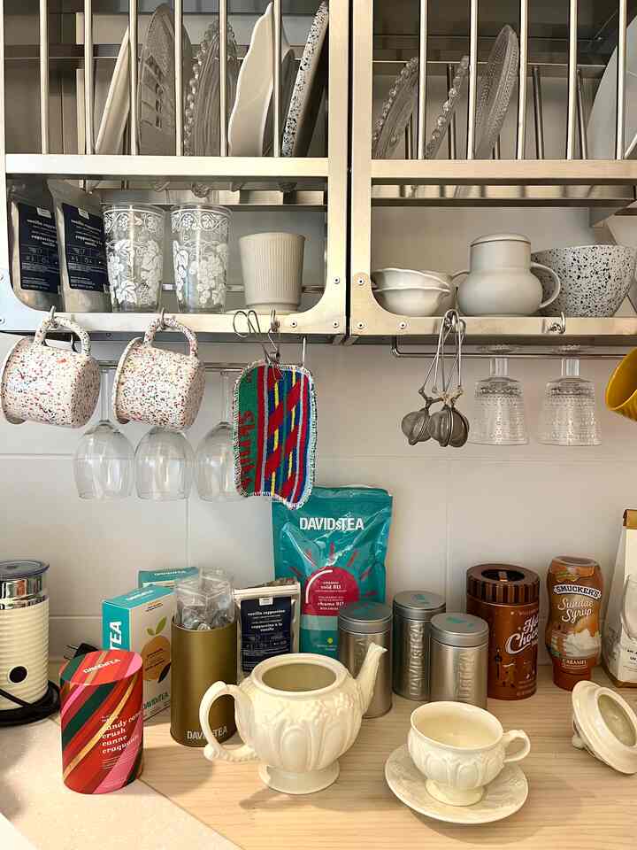 ナチュラルな色調のキッチン、様々なティーカップとキッチン用品が整った雰囲気のあるインテリア