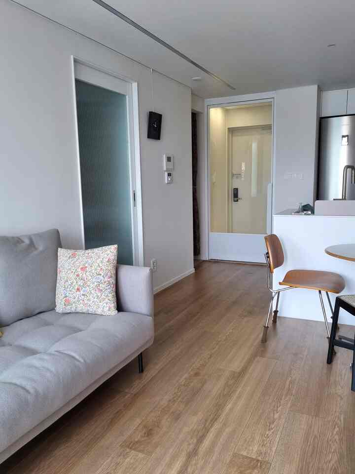 ナチュラルな木目調の床が特徴のシンプルモダンなリビングとキッチンスペース