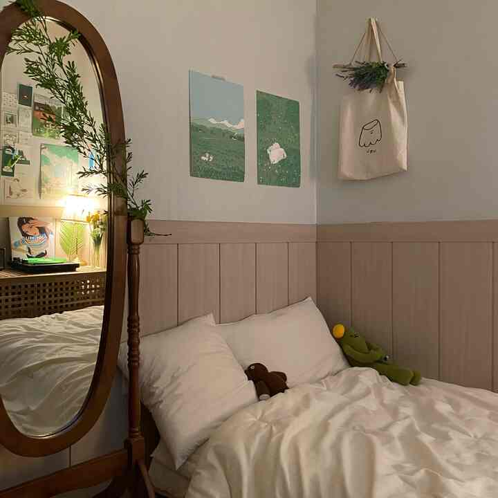 アイボリーとナチュラルトーンの寝室、全身鏡と壁のポスター、エコバッグで飾られた居心地の良い空間