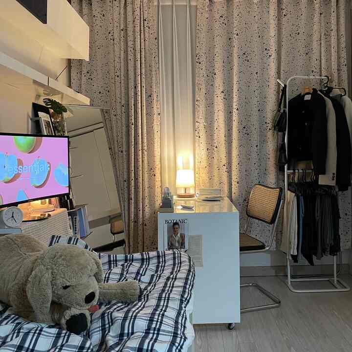 ベージュとホワイトのトーンでまとめられた一人暮らし用のワンルーム寝室、細いフレームの家具とシンプルなインテリアが印象的な空間