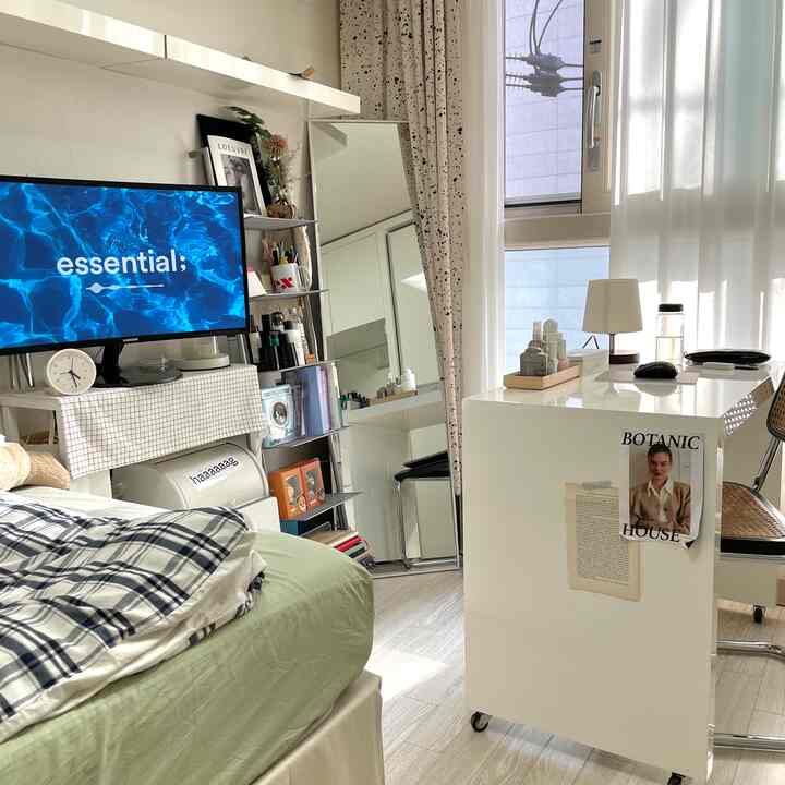 ホワイトとナチュラルカラーの寝室、ベッドと全身鏡、白いデスクが配置された落ち着いた一人暮らしの空間