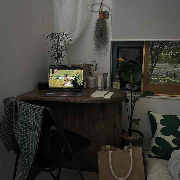 ホワイトとダークブラウンの色調のコンパクトなホームオフィス、植物とデスクが配置された自然でミニマルな雰囲気のインテリア