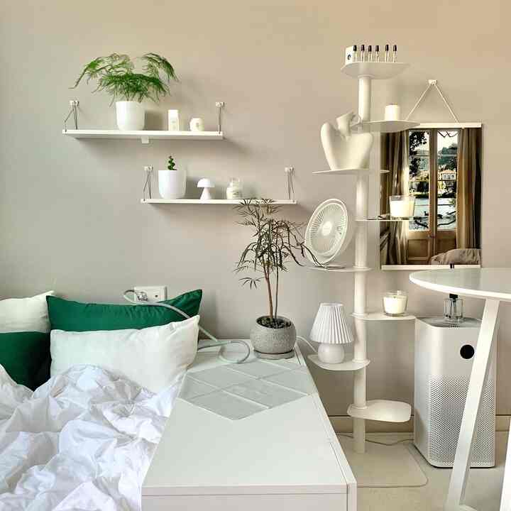 白と緑のトーンの寝室、快適な寝具と植物が配置されたシンプルで清潔感のあるインテリア