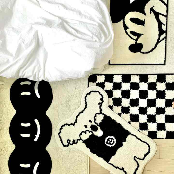 ホワイトトーンの書斎、かわいいキャラクターとモノトーンパターンのラグが配置された雰囲気のあるインテリア