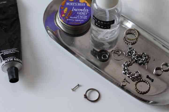 シルバーのトレイに銀のアクセサリーとケア用品が置かれた清潔なナイトテーブルの空間