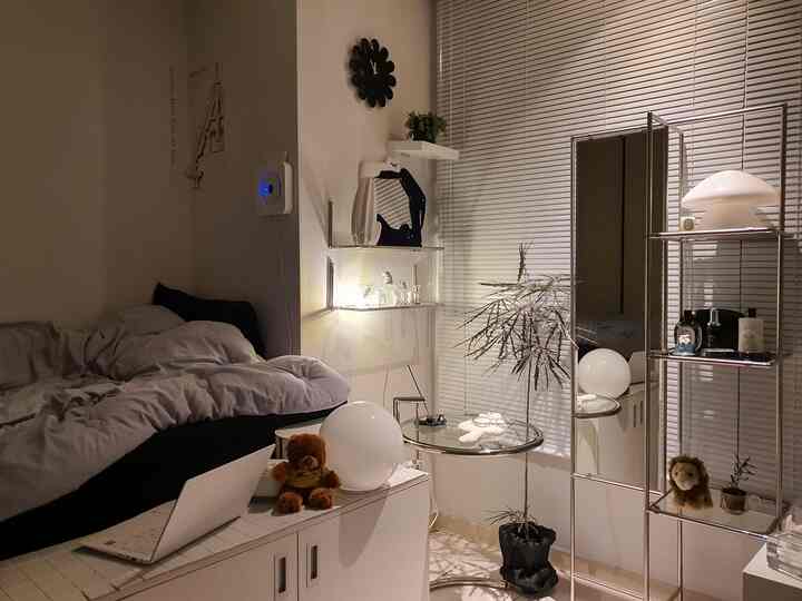 モノトーンとシルバートーンが調和した寝室、ベッドとアルミブラインドが配置され、落ち着いた集中できる雰囲気のインテリア