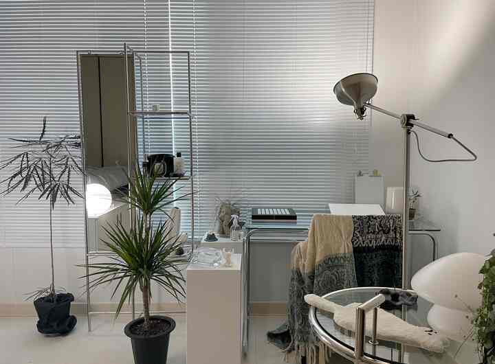 白とシルバーの色調のホームオフィス、ガラス製デスクと全身鏡、フロアランプが配置されたミッドセンチュリーモダンなインテリア