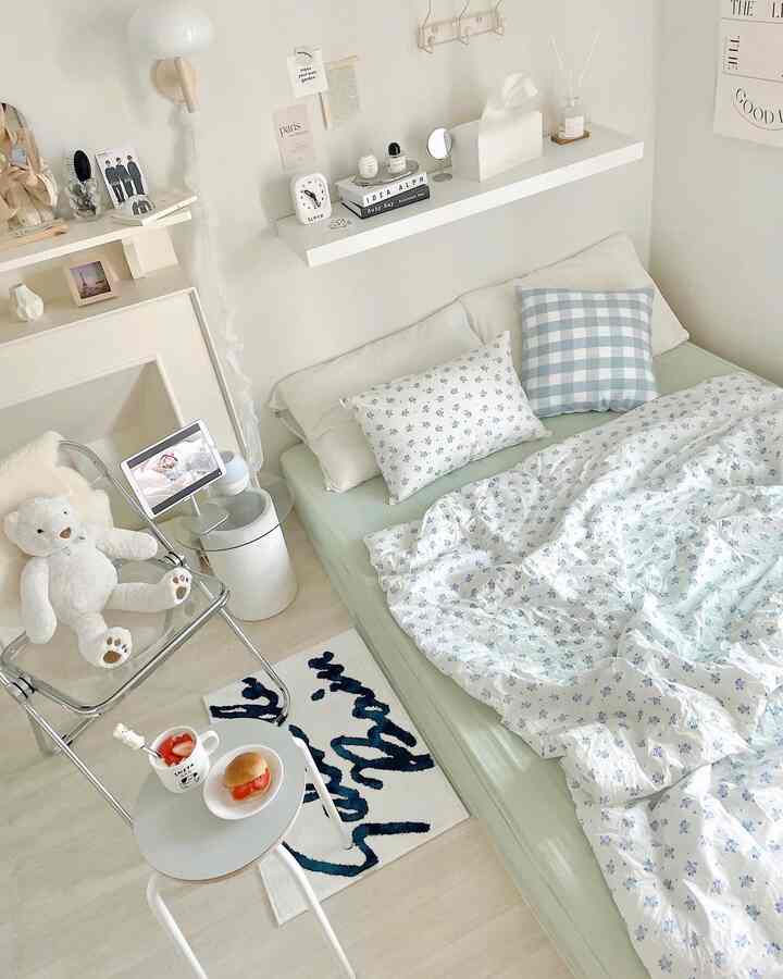 明るい白と青のトーンの寝室、快適なベッドと透明な椅子が配置された居心地の良い空間