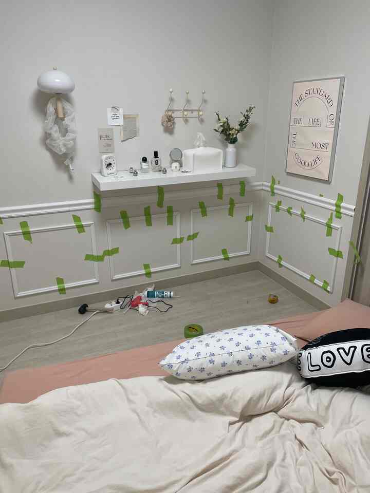 ホワイトとベージュのトーンの寝室、壁にフレンチスタイルのモールディングと壁棚が配置された雰囲気のあるインテリア