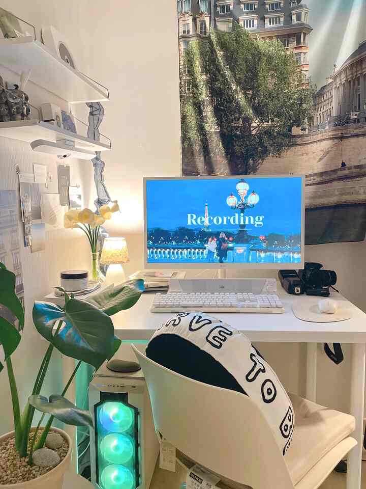 白と緑のトーンのホームオフィス、コンパクトなデスクと椅子、モニターと植物が配置された雰囲気のある作業空間