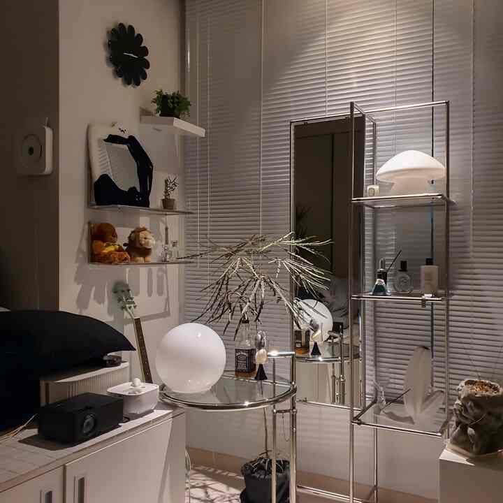 シルバーとホワイトのトーンの小さな空間、全身鏡とモジュール家具が配置されたモダンでギャラリーのようなインテリア