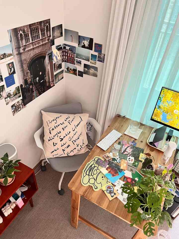ベージュとナチュラルな色調のコンパクトなホームオフィス、木製の机、グレーのオフィスチェアと植物が配置された雰囲気のあるインテリア