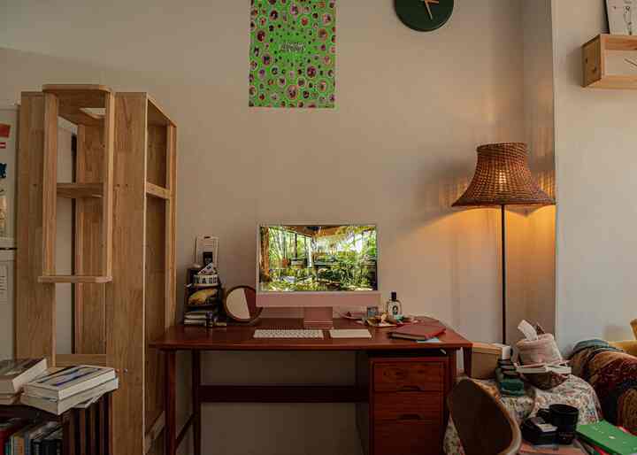 木目調と白い壁のホームオフィス、机とフロアランプが配置された落ち着いた作業空間