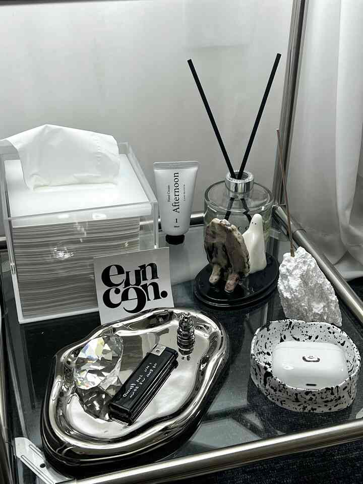 モノトーン調の棚にディフューザーとオブジェが配置された洗練された空間