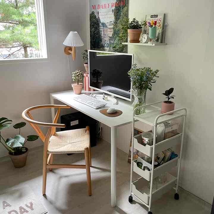 ホワイトとナチュラルトーンのホームオフィス、デスク上にモニターと植物が配置された清潔感のある居心地の良い作業空間