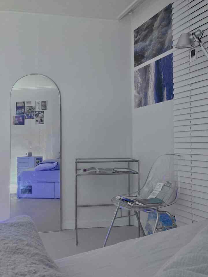 ホワイトトーンの寝室、透明なチェアと金属製シェルフが配置されたシンプルでモダンなインテリア