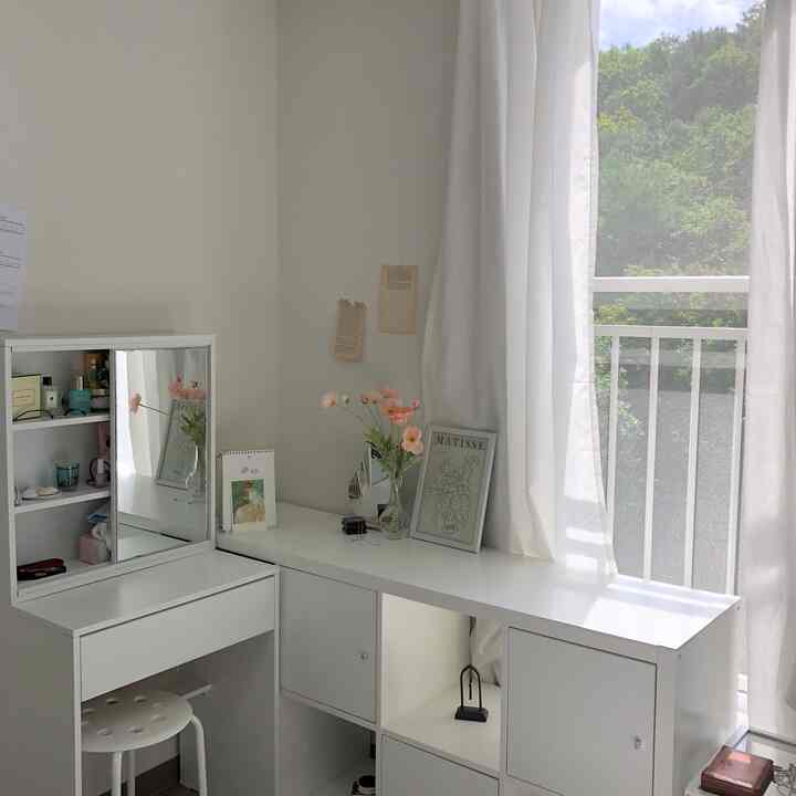 ホワイトトーンのコンパクトな部屋、化粧台と棚を組み合わせた空間活用のインテリアと明るい窓辺の雰囲気