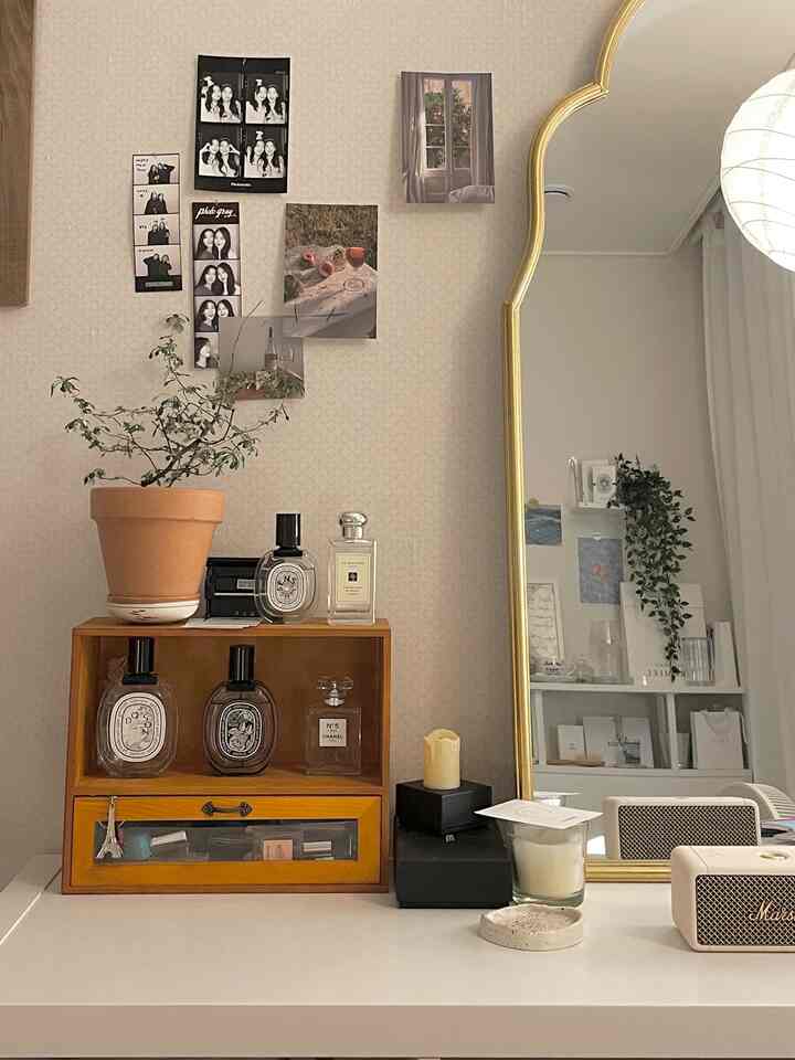 白と茶色のトーンの鏡と植物、小物が配置されたシンプルな雰囲気の空間