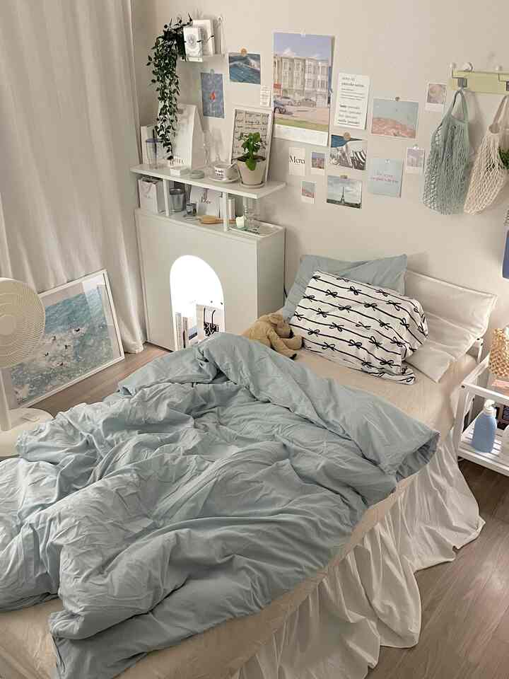 白とミント色の寝室、壁にポスターが貼られ、中央にシングルベッドが配置された落ち着いた空間