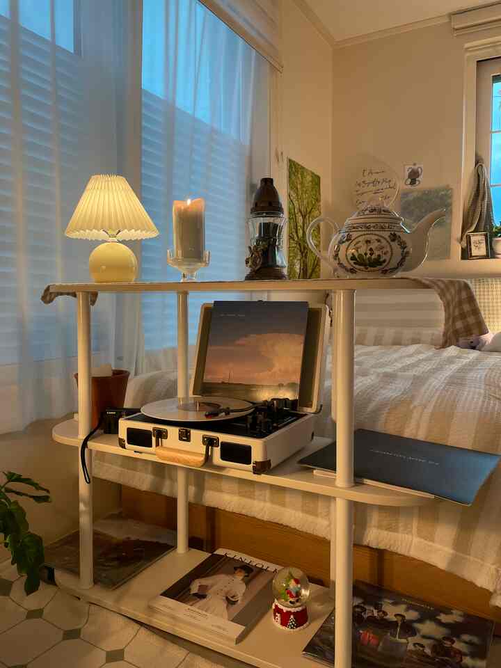 ホワイトとナチュラルカラーの小さな部屋、LPターンテーブルとキャンドルの灯りが配置されたモダンな空間