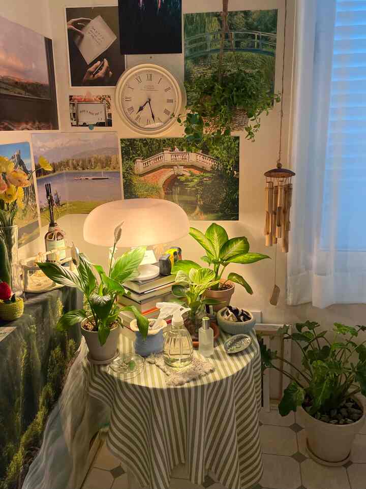 白と緑のトーンの小さな空間、植物とテーブルランプが配置された雰囲気のあるインテリア