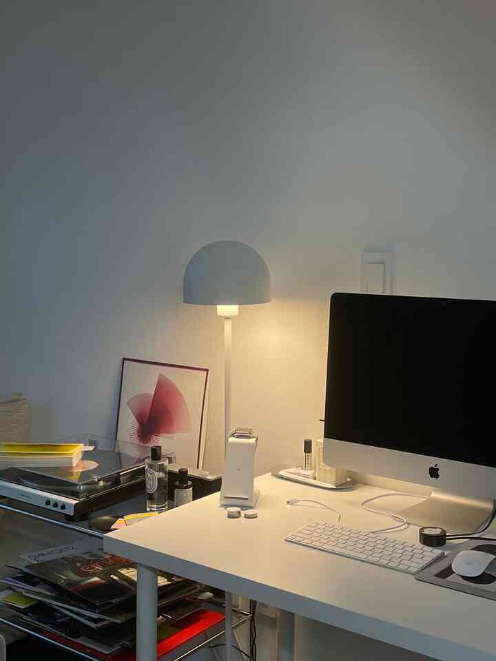 白を基調としたホームオフィス空間、白いデスクとモダンなテーブルランプが配置された清潔感のあるインテリア