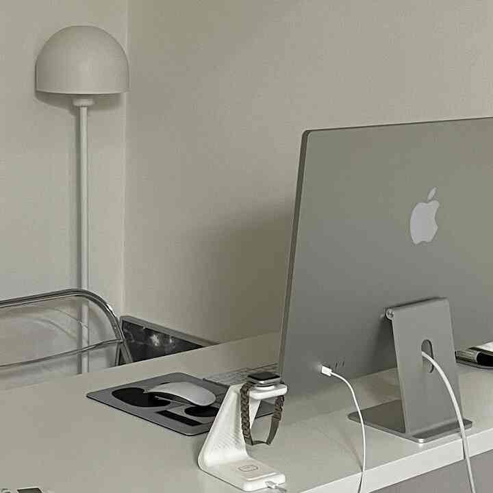 ホワイトとシルバーのトーンのホームオフィス、モダンなデスクとコンピューター、透明な椅子が配置された整った作業空間