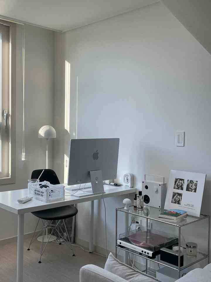 明るいホワイトトーンのホームオフィス、シンプルなデスクとチェアに整頓された収納が配置されたモダンなインテリア