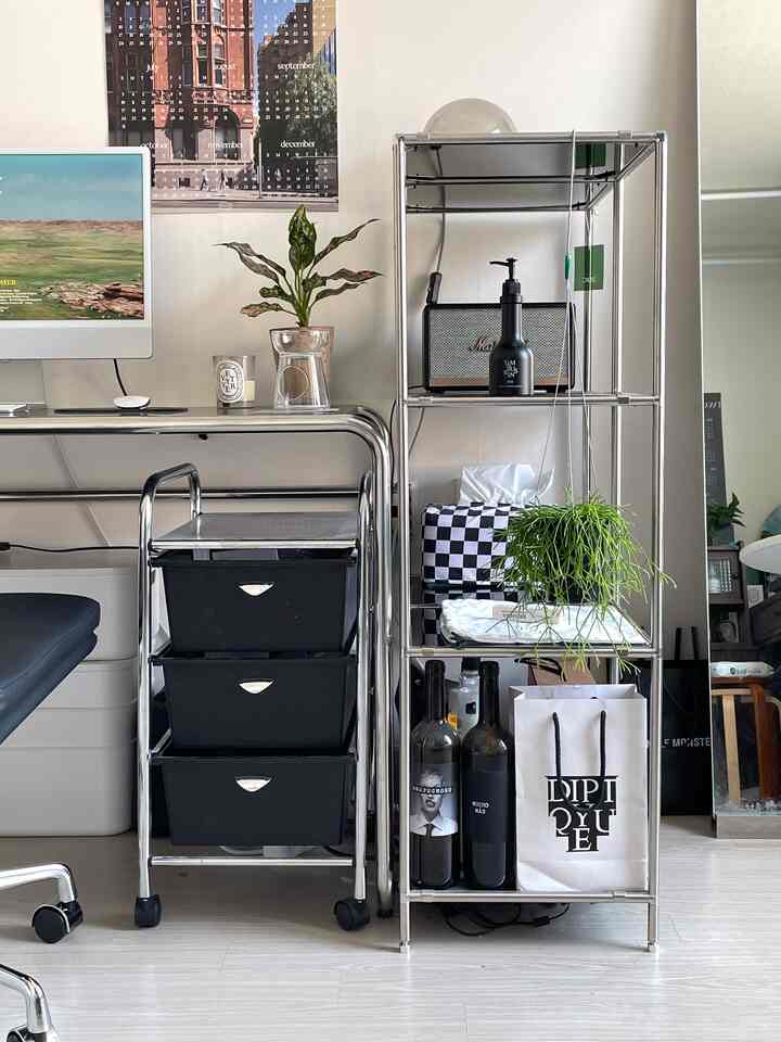 白とスチール調のホームオフィス、クロームフレームのデスクと移動式の引き出しが配置された印象的な空間。